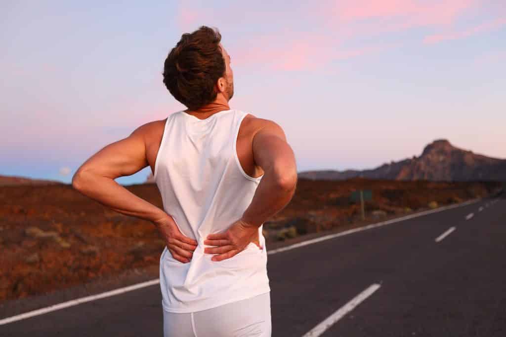 Back,Pain.,Athletic,Running,Man,With,Injury,In,Sportswear,Rubbing