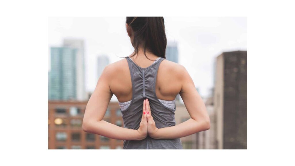 Woman facing away completing sciatica pain relief exercise. 